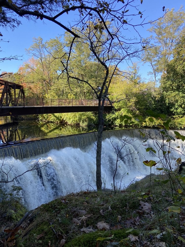 A footbridge crosses the Yantic River above the waterfall in Norwich Connecticut.