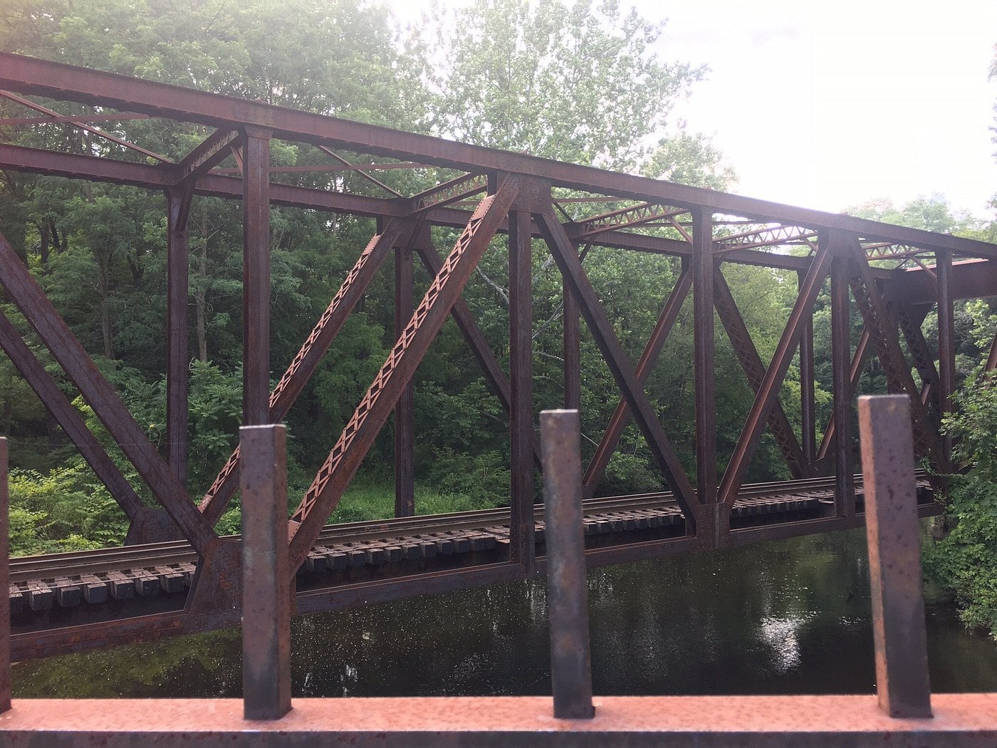 A railroad bridge crosses near the rocky gorge at Yantic Falls.