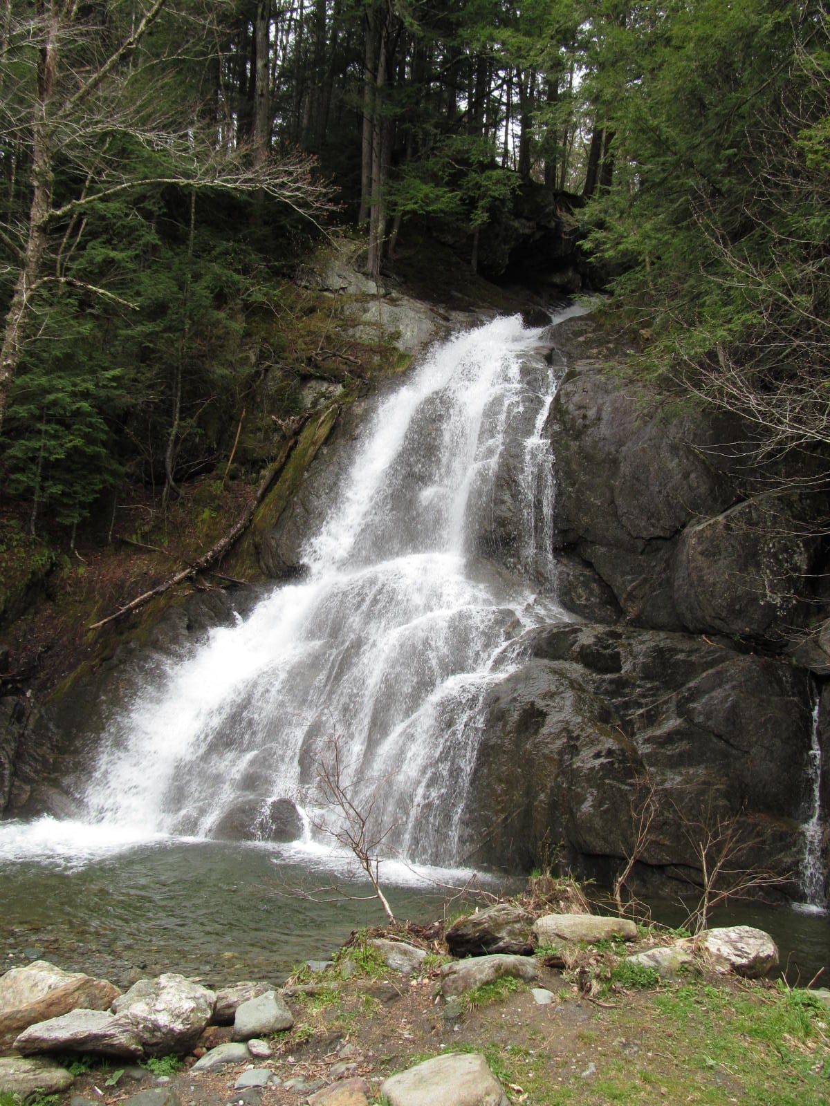 Side view of Moss Glen Falls in Granville with whitewater spreading across rock ledges.