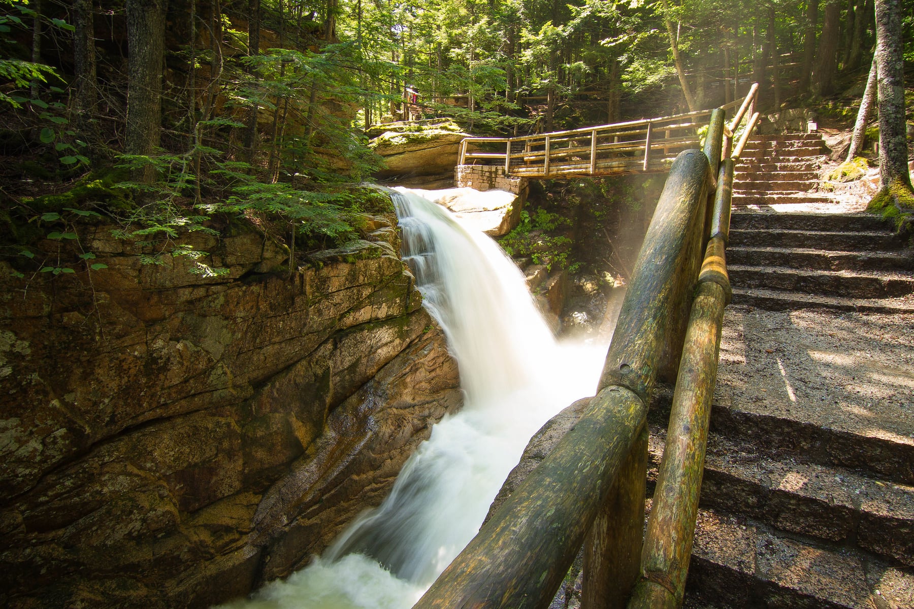 Sabbaday Falls drops through a narrow rocky gorge below the bridge.
