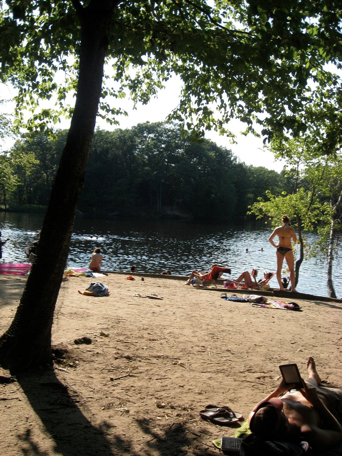 Sandy shoreline and swimmers at Puffer's Pond in Amherst, Massachusetts.