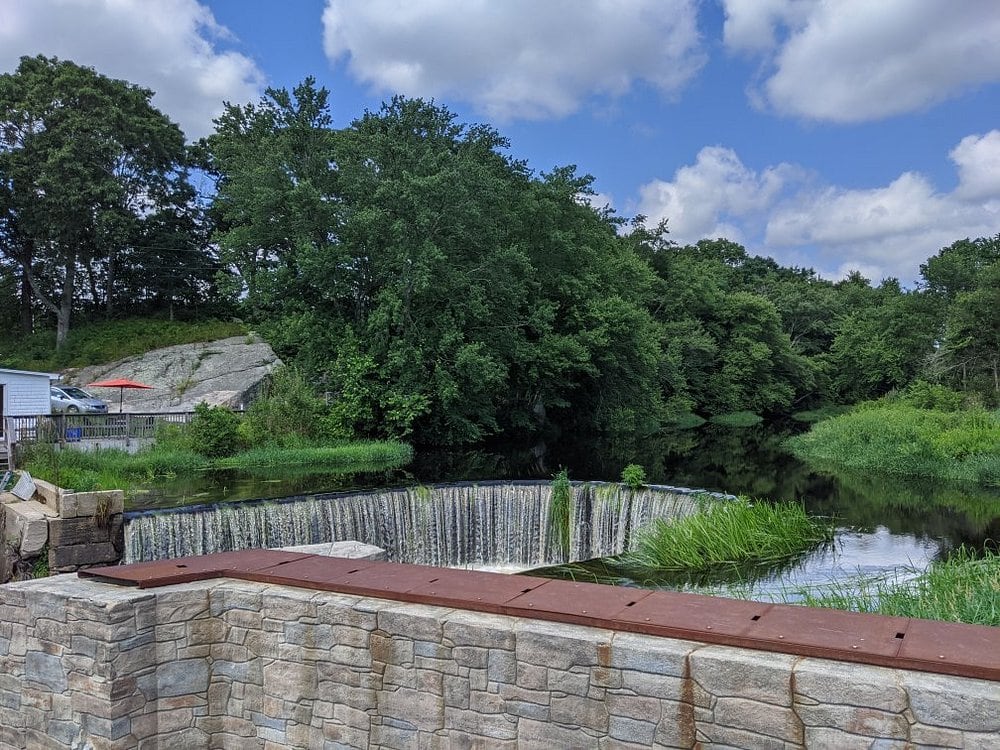 A stone overlook frames the broad horseshoe spillway at Shannock Horseshoe Falls.