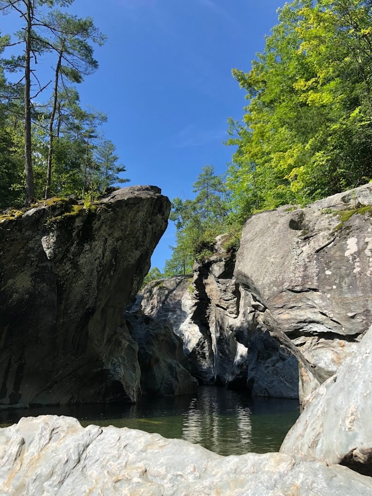 Blue sky and bright forest frame the rock walls above Huntington Gorge.