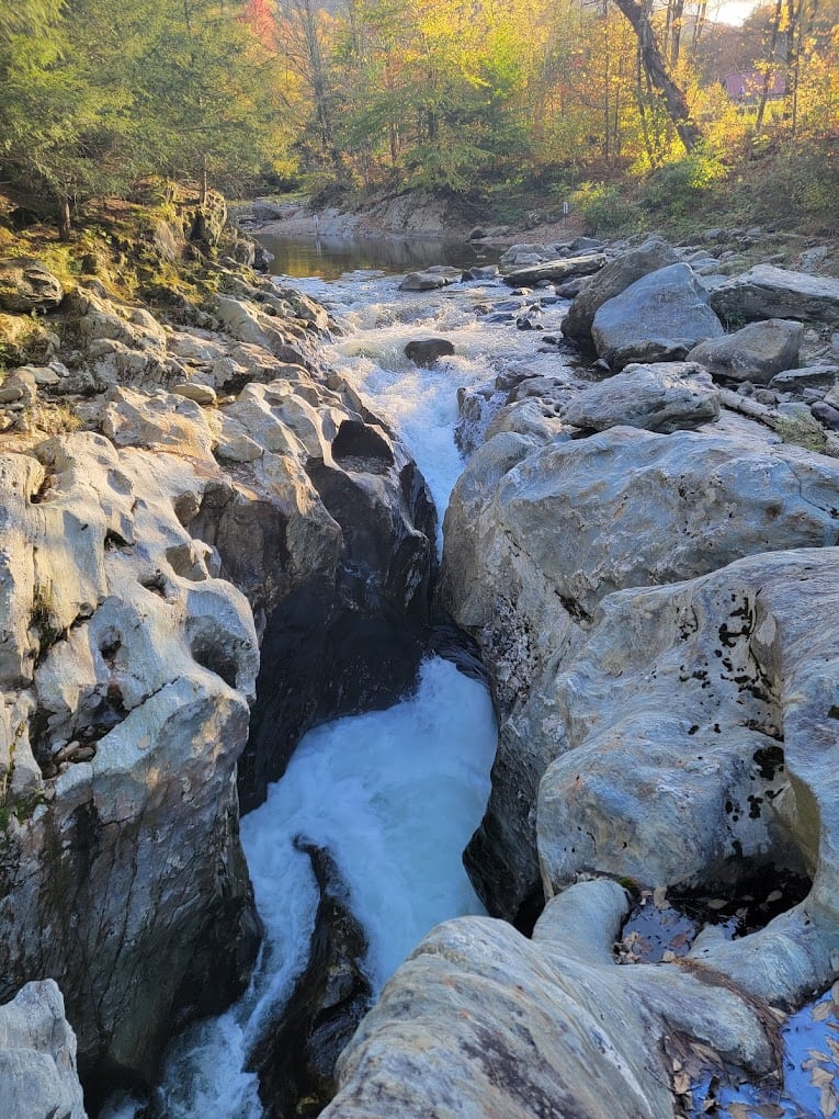 Whitewater squeezes through pale bedrock in the upper Huntington Gorge.